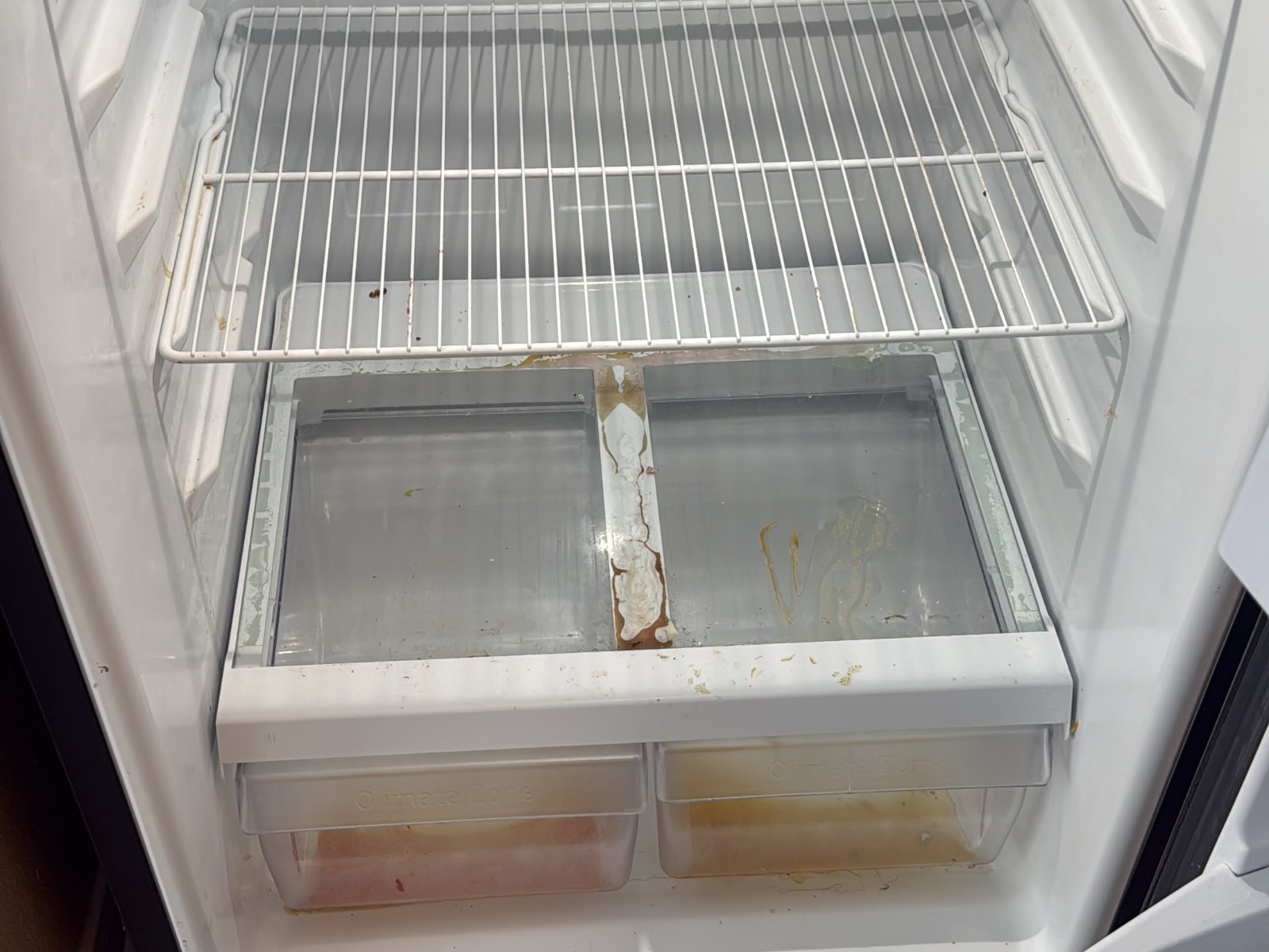 Refrigerator interior with spills and stains before cleaning